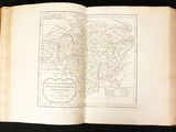 an open book with a map of india on it on a black surface