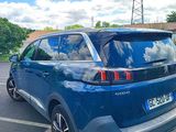 the rear end of a blue car parked in a parking lot