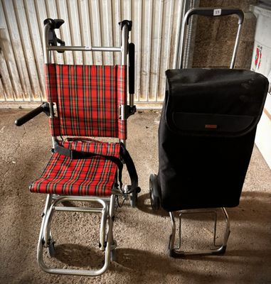 a red and black chair next to a black suitcase