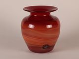 a red glass vase with a black handle on a white background
