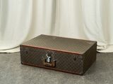 a suitcase sitting on the floor in front of a curtain