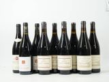 six bouteilles de vin sont alignées sur une surface blanche