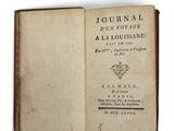 un livre ouvert posé sur une surface blanche, avec l'image d'une couronne