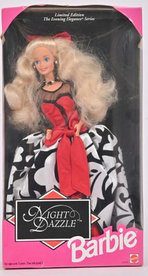 La poupée Barbie porte une robe noire et blanche ornée d'un nœud rouge.