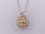 a close up of a necklace with a pear shaped yellow diamond