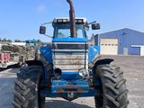 a blue tractor that is parked in a parking lot