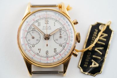 une montre en or avec un cadran blanc et une étiquette