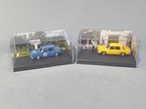 two miniature cars that are sitting in a display case