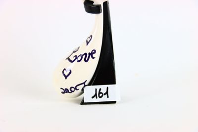 une figurine représentant une femme tenant une pancarte sur laquelle on peut lire « Je t'aime, papa »