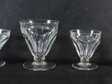 quatre verres à pied sont alignés sur une surface noire