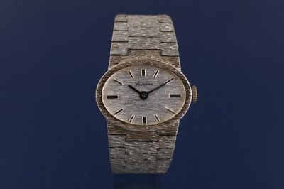 un gros plan d'une montre-bracelet posée sur une surface bleue
