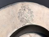 a silver plate with a design on it