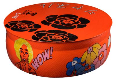 an orange round box with a picture of a woman and flowers on it