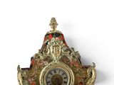 a clock that is sitting on a shelf on the wall
