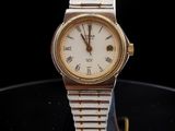 an image of a gold and silver watch on a black surface