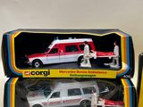 two boxed boxed toys of a white and red ambulance and a red and white car