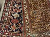 two oriental rugs on the floor in a room with a red chair