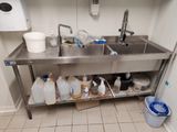 un évier sur lequel sont posés de nombreuses bouteilles et récipients