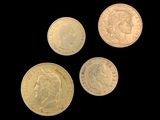 four different types of gold coins on a black background