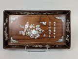 une image représentant un plateau en bois orné de fleurs et de feuilles