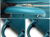 the inside of a blue purse with a zipper and a zippered handle