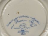 une assiette blanche avec une inscription bleue dessus
