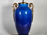une image représentant un vase bleu muni d'une anse dorée sur fond blanc