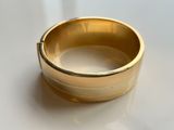 a close up of a gold ring on a white surface