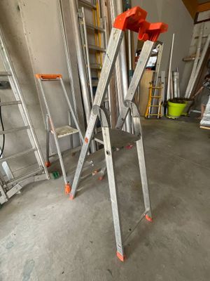 de nombreuses échelles entreposées dans un garage