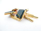 three gold cufflinks with a blue stone on them on a white surface