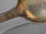 a silver spoon with a spoon handle on a table
