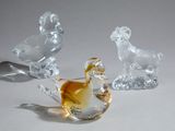 trois figurines en verre représentant des animaux, posées sur une table