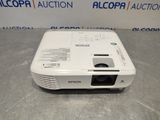 a white projector sitting on top of a table next to a wall