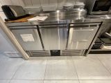 un plan de travail en acier inoxydable sur lequel sont posés un micro-ondes et un grille-pain