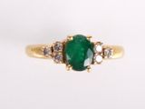 bague ovale en émeraude et diamant sur fond blanc