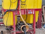 a yellow tank sitting on a pallet with a hose attached to it