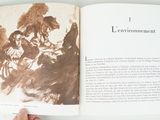 a person holding an open book with a picture of a man and a woman
