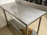 une table en acier inoxydable dans une cuisine équipée d'un micro-ondes