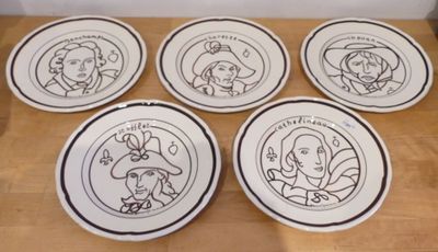 six assiettes ornées de personnages de dessins animés, posées sur une table en bois