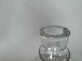 a clear glass vase sitting on top of a glass plate