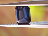 un gros plan d'un diamant bleu en train d'être taillé à l'aide d'une paire de pinces