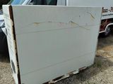 a white truck with a broken door sitting in a lot