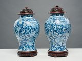 une paire de vases chinois bleus et blancs posés sur un socle, sur une table
