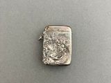 a close up of a silver lighter with a dragon on it