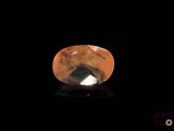 a close up of a yellow and black diamond on a black surface