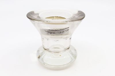 un petit vase en verre contenant une bougie