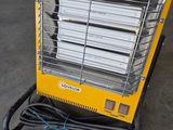 a yellow heater sitting on a cart in a garage