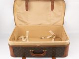 a brown and tan suitcase sitting on a white surface