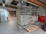 many cages that are stacked on pallets in a warehouse