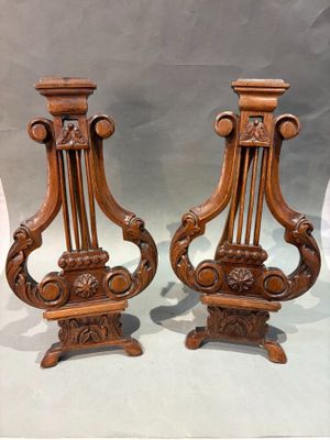 pair of carved wood candlesticks in the shape of harps